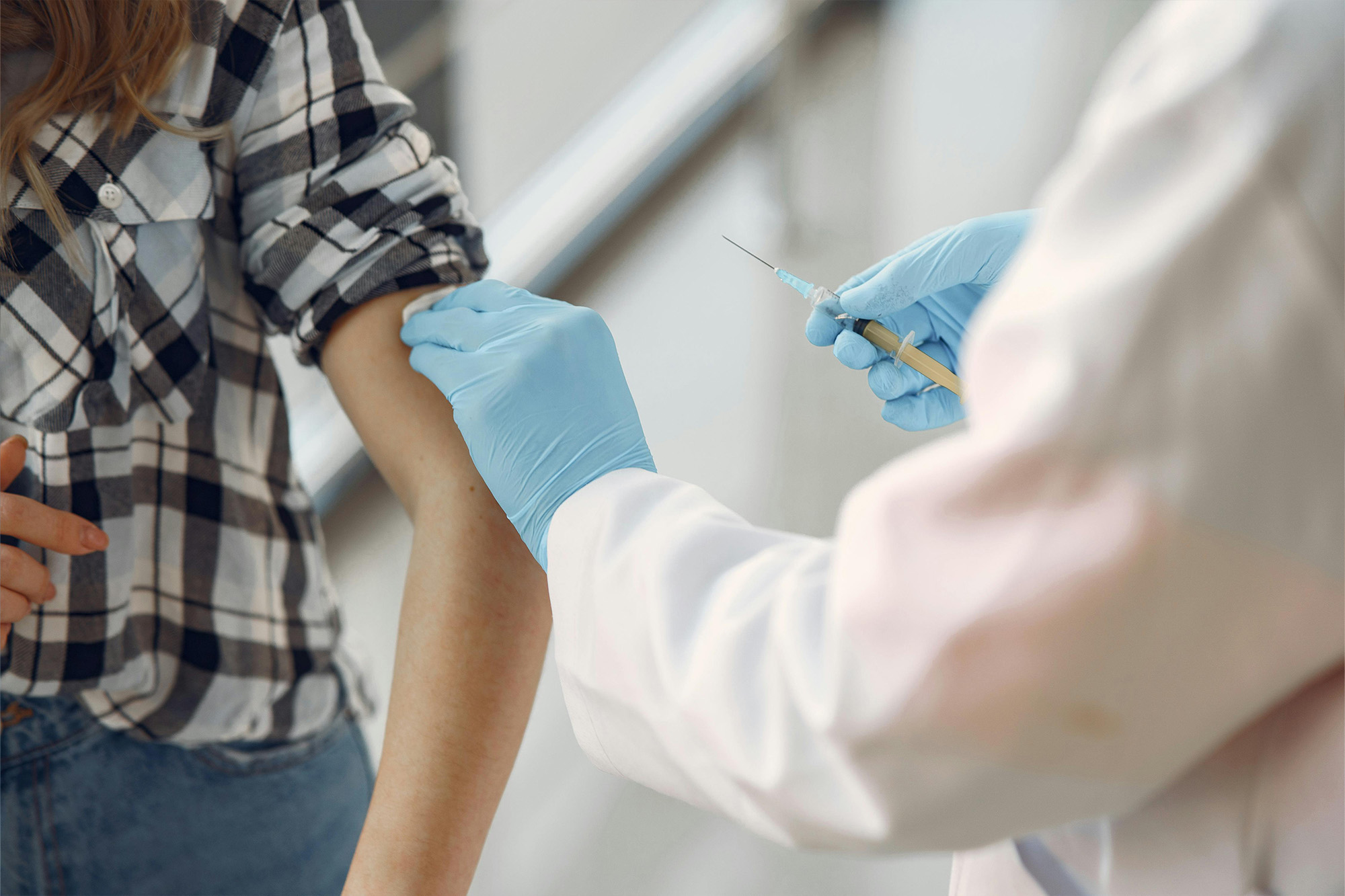 Healthcare professional administering vaccinations during a prenatal check-up at a women's care clinic.